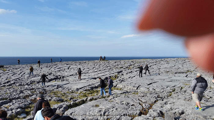 Original landscape before editing — finger and visitors visible